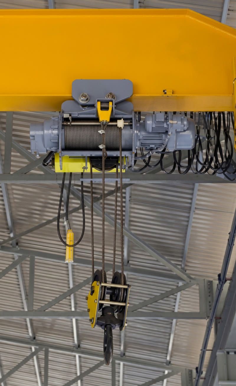 Overhead bridge crane system spanning a warehouse facility floor